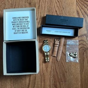 Shinola gold band watch with brown leather strap.
